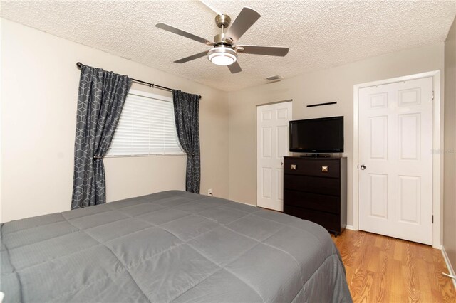 9870 36th Way N, Pinellas Park, FL 33782 - bedroom with light wood-style flooring, a textured ceiling, and ceiling fan