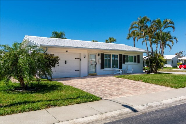 9870 36th Way N, Pinellas Park, FL 33782 - ranch-style house with decorative driveway, a garage, a tiled roof, a front lawn, and stucco siding