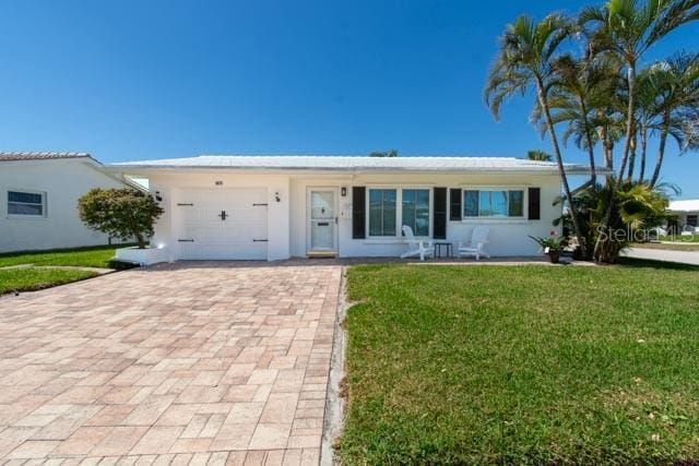 9870 36th Way N, Pinellas Park, FL 33782 - ranch-style house featuring a garage, decorative driveway, a front yard, and stucco siding