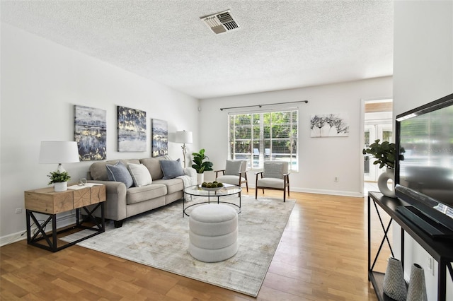 3818 W San Miguel St, Tampa, FL 33629 - living area featuring light wood finished floors, baseboards, visible vents, and a textured ceiling