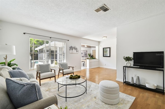 3818 W San Miguel St, Tampa, FL 33629 - living room with wood finished floors, a textured ceiling, baseboards, and visible vents