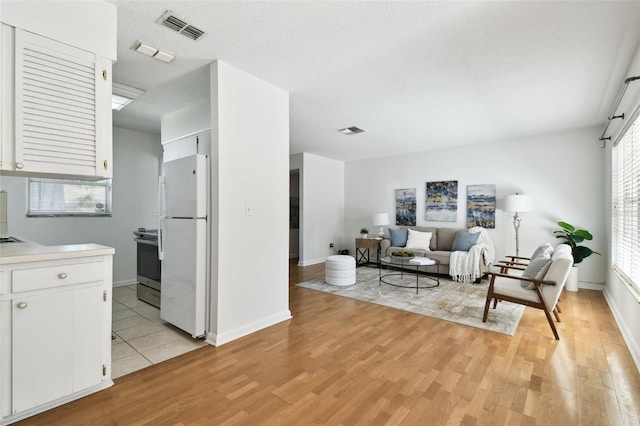 3818 W San Miguel St, Tampa, FL 33629 - living area with baseboards, a textured ceiling, visible vents, and light wood finished floors
