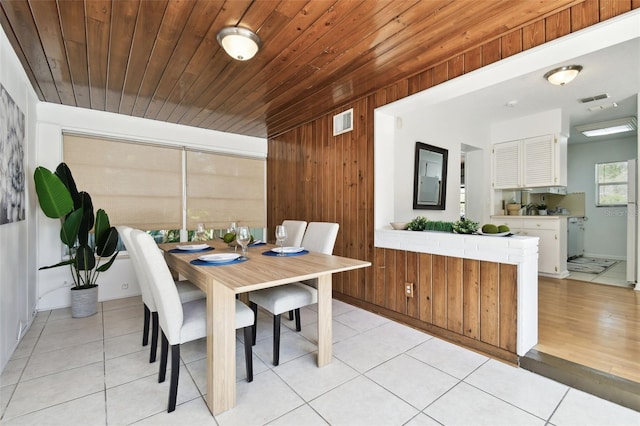 3818 W San Miguel St, Tampa, FL 33629 - dining area featuring wood ceiling, visible vents, light tile patterned floors, and wood walls