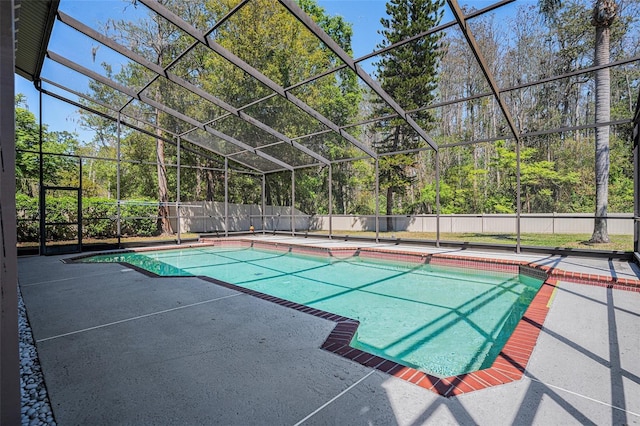 view of swimming pool featuring a patio, fence, and a lanai