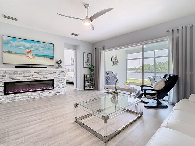 2327 Shirecrest Cove Way, Lutz, FL 33558 - living room with a ceiling fan, wood finished floors, a fireplace, and a water view