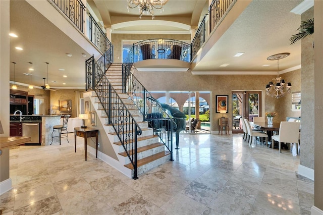 entrance foyer featuring baseboards, crown molding, and stairs
