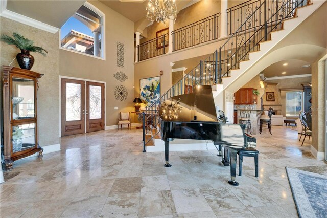 entryway featuring a high ceiling, crown molding, stairs, and baseboards