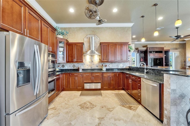 kitchen with wall chimney range hood, a sink, a warming drawer, stainless steel appliances, and ornamental molding