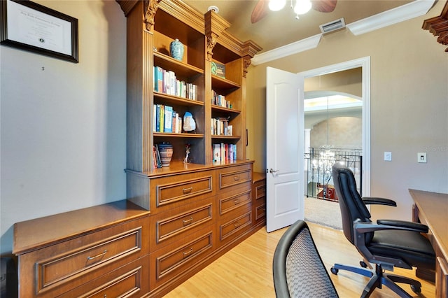 office area featuring a ceiling fan, light wood-type flooring, arched walkways, ornamental molding, and visible vents