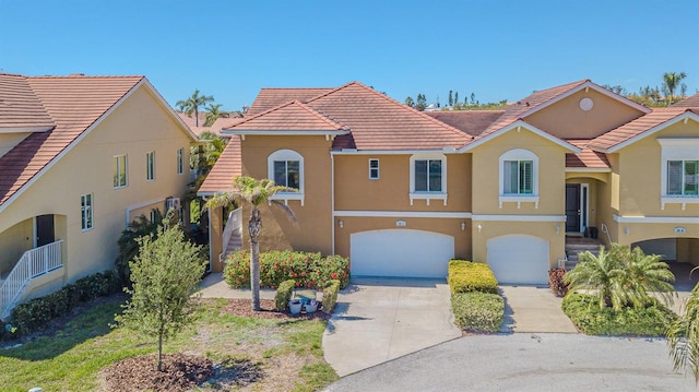 16 Franklin Ct S Unit A, Saint Petersburg, FL 33711 - view of front of house featuring concrete driveway, a garage, stucco siding, and a tiled roof
