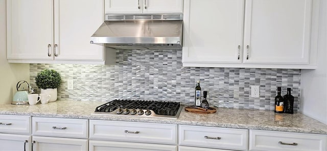 16 Franklin Ct S Unit A, Saint Petersburg, FL 33711 - kitchen featuring under cabinet range hood, stainless steel gas stovetop, backsplash, and white cabinets