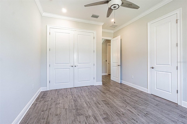 16 Franklin Ct S Unit A, Saint Petersburg, FL 33711 - unfurnished bedroom featuring wood finished floors, a closet, crown molding, visible vents, and baseboards