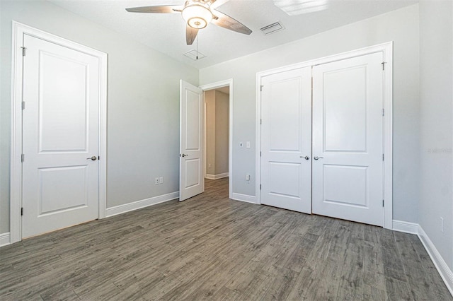 16 Franklin Ct S Unit A, Saint Petersburg, FL 33711 - unfurnished bedroom featuring a closet, wood finished floors, visible vents, a ceiling fan, and baseboards