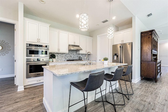 16 Franklin Ct S Unit A, Saint Petersburg, FL 33711 - kitchen with wood finished floors, a sink, baseboards, appliances with stainless steel finishes, and decorative backsplash