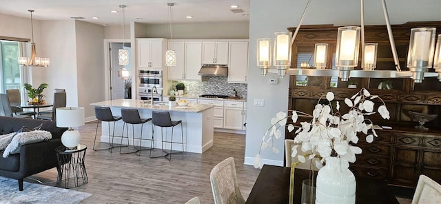 16 Franklin Ct S Unit A, Saint Petersburg, FL 33711 - kitchen featuring an inviting chandelier, open floor plan, light wood-style floors, appliances with stainless steel finishes, and tasteful backsplash