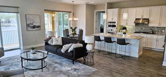 16 Franklin Ct S Unit A, Saint Petersburg, FL 33711 - living room featuring an inviting chandelier, dark wood-type flooring, baseboards, and recessed lighting