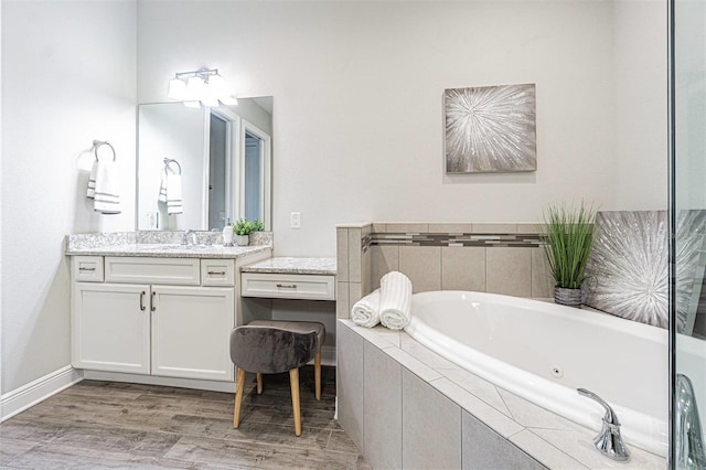 16 Franklin Ct S Unit A, Saint Petersburg, FL 33711 - bathroom featuring a garden tub, baseboards, wood finished floors, and vanity