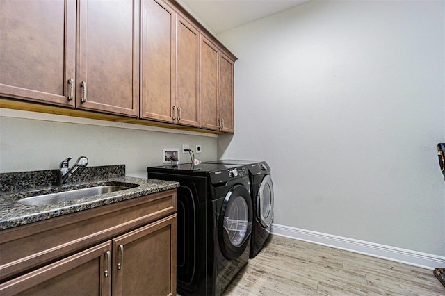 16 Franklin Ct S Unit A, Saint Petersburg, FL 33711 - washroom with a sink, cabinet space, separate washer and dryer, light wood-type flooring, and baseboards