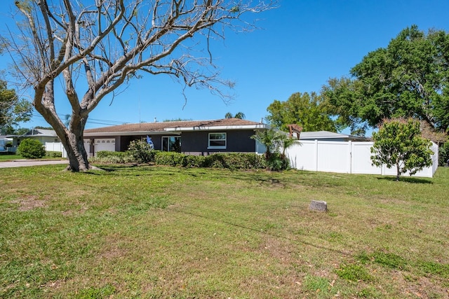 1828 Stancel Dr, Clearwater, FL 33764 - view of front of home featuring a front yard, fence, driveway, an attached garage, and stucco siding
