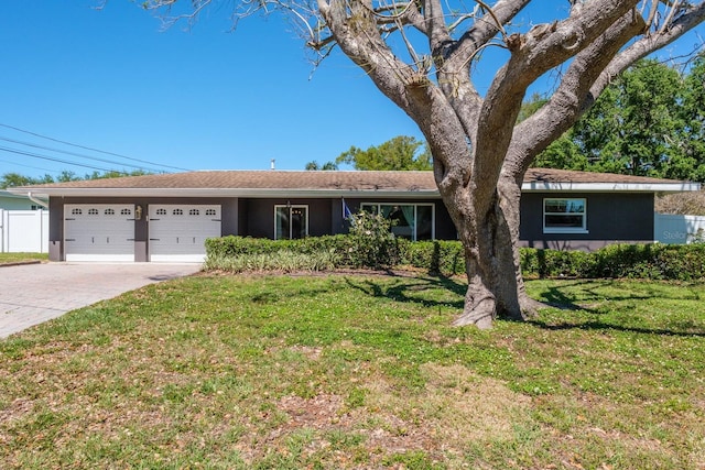 1828 Stancel Dr, Clearwater, FL 33764 - ranch-style home with stucco siding, a front lawn, driveway, fence, and a garage