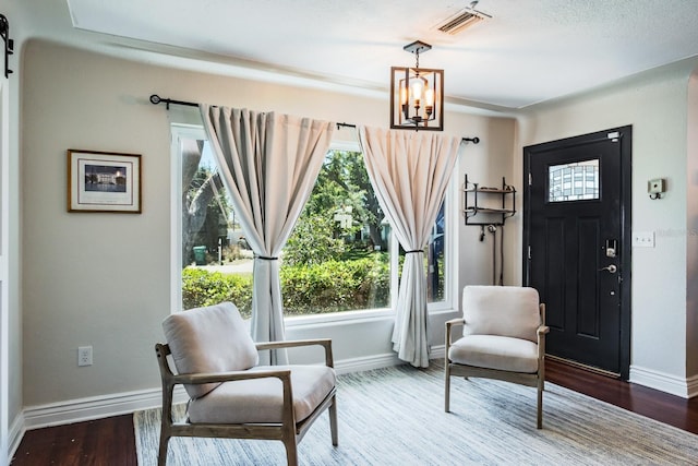 1828 Stancel Dr, Clearwater, FL 33764 - living area with visible vents, baseboards, an inviting chandelier, and wood finished floors