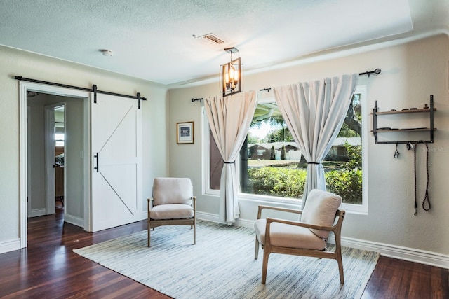 1828 Stancel Dr, Clearwater, FL 33764 - living area featuring baseboards, a barn door, and wood finished floors
