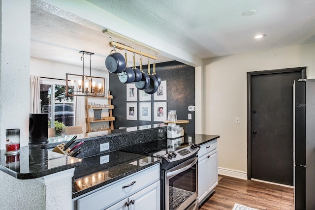 1828 Stancel Dr, Clearwater, FL 33764 - kitchen with white cabinetry, stainless steel range with electric stovetop, dark wood-style floors, and freestanding refrigerator