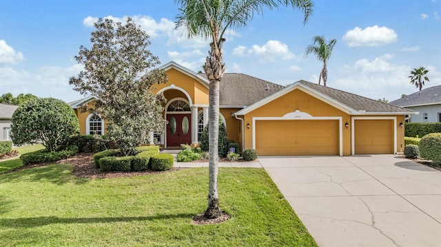 view of front of home featuring a front yard, stucco siding, an attached garage, and concrete driveway