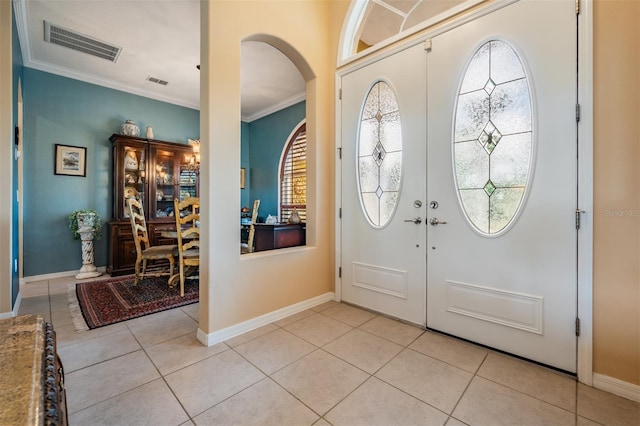 entrance foyer featuring crown molding, arched walkways, visible vents, and light tile patterned floors