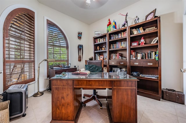 home office with a ceiling fan and light tile patterned floors