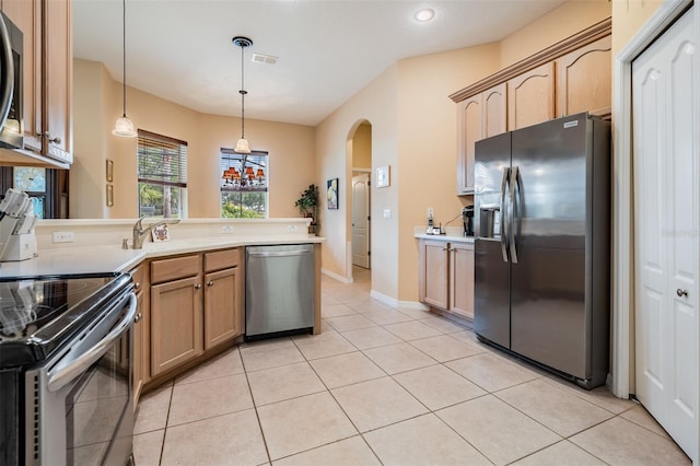 kitchen featuring a sink, arched walkways, light tile patterned flooring, a peninsula, and appliances with stainless steel finishes