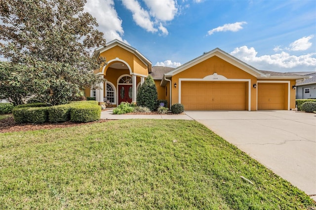 view of front of home featuring driveway, an attached garage, a front yard, and stucco siding