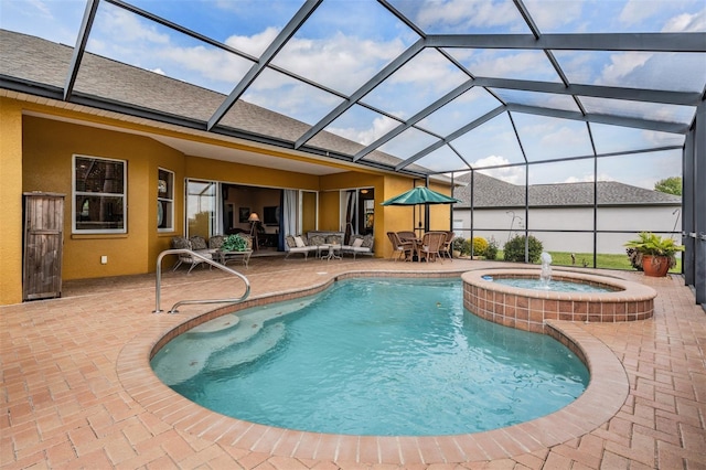 view of pool featuring a pool with connected hot tub, glass enclosure, and a patio area