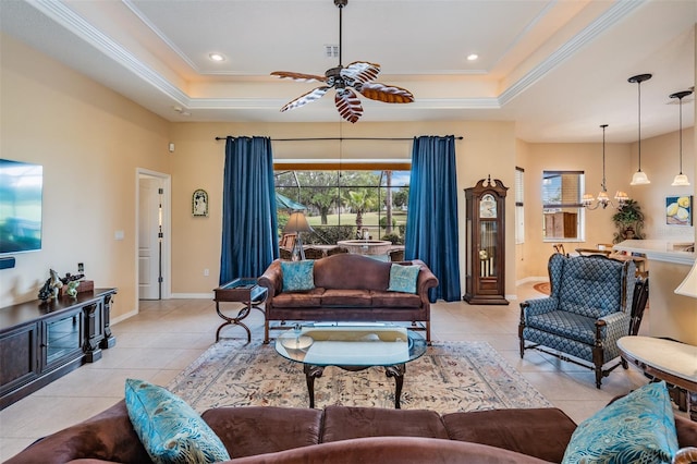 living room featuring ceiling fan with notable chandelier, a raised ceiling, and crown molding