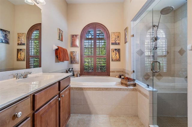 bathroom with tile patterned floors, vanity, a garden tub, and a shower stall