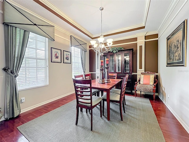 dining area with ornamental molding, a healthy amount of sunlight, wood finished floors, and a chandelier
