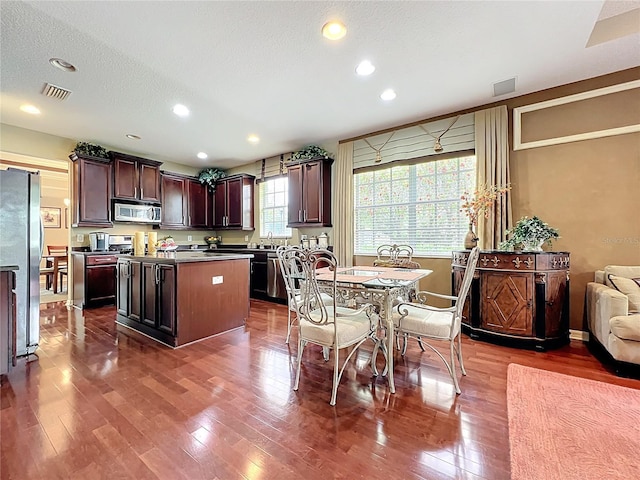 kitchen featuring dark wood-type flooring, visible vents, appliances with stainless steel finishes, and dark brown cabinetry
