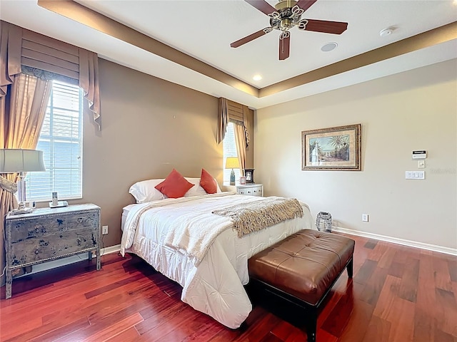 bedroom featuring wood finished floors, baseboards, and multiple windows