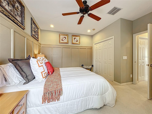 bedroom featuring visible vents, recessed lighting, light colored carpet, a closet, and a decorative wall