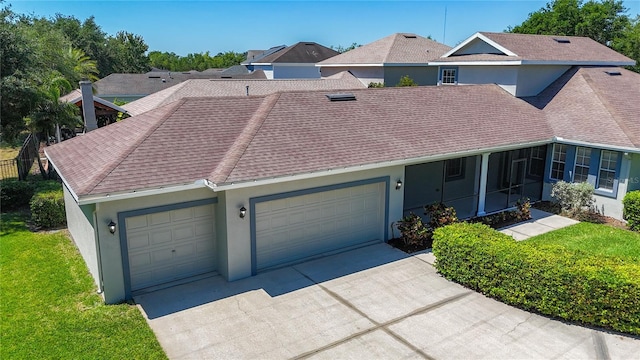 townhome / multi-family property featuring a shingled roof, stucco siding, concrete driveway, a front yard, and a garage