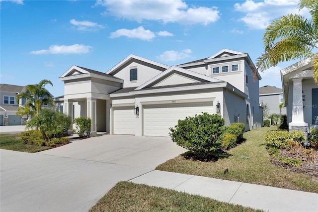 view of front facade featuring concrete driveway, stucco siding, and a garage