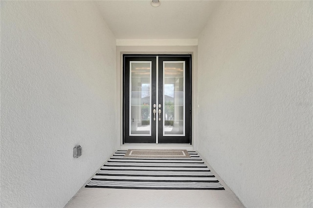 doorway to property featuring french doors and stucco siding