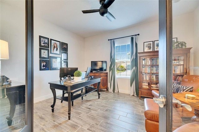 office space with baseboards, a ceiling fan, and wood finish floors