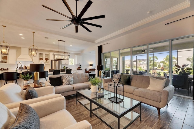 living area featuring ornamental molding, recessed lighting, wood finish floors, and ceiling fan with notable chandelier