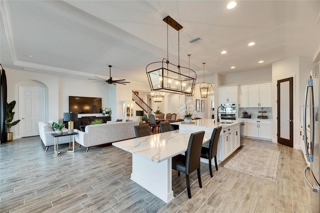 kitchen featuring white cabinets, visible vents, a sink, and wood tiled floor
