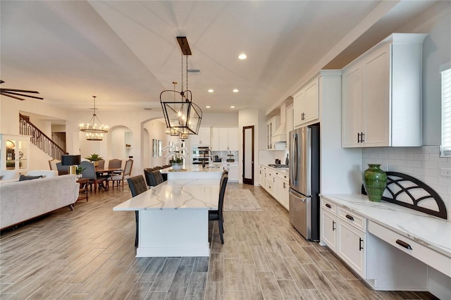 kitchen featuring open floor plan, tasteful backsplash, white cabinets, and stainless steel appliances