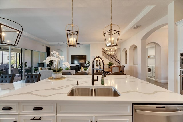 kitchen with open floor plan, visible vents, appliances with stainless steel finishes, arched walkways, and a sink