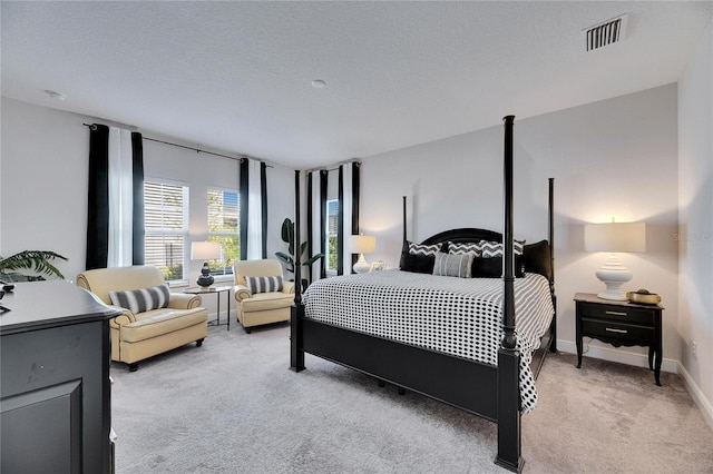 bedroom featuring a textured ceiling, light colored carpet, baseboards, and visible vents