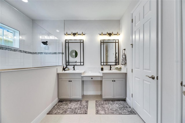 full bath with two vanities, tile patterned flooring, a sink, walk in shower, and baseboards