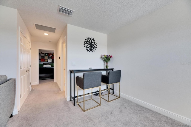 office featuring a textured ceiling, baseboards, carpet, and visible vents
